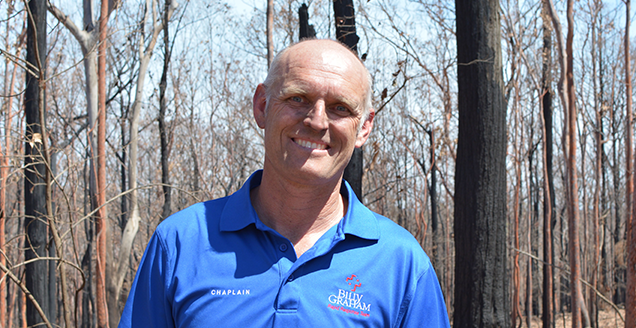 Stewart Beveridge in front of burnt trees