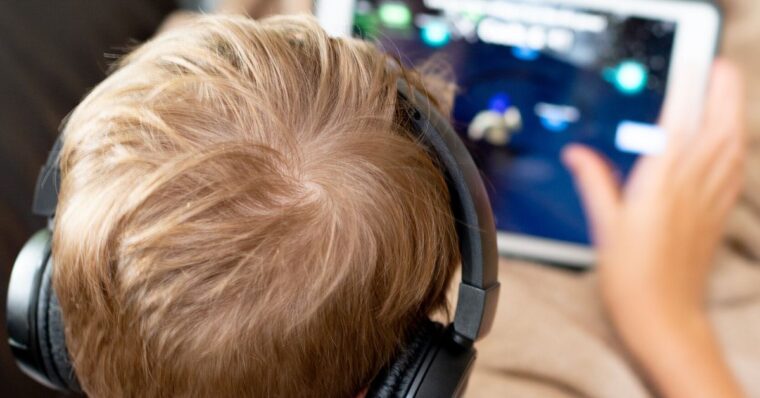 Boy from Gen Alpha playing game on ipad