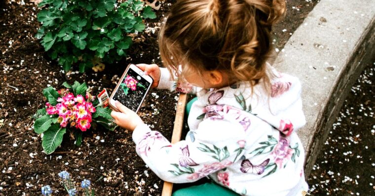 Girl from Gen Alpha using her digital skills taking photo of plant on iphone